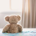 brown bear plush toy on bed
